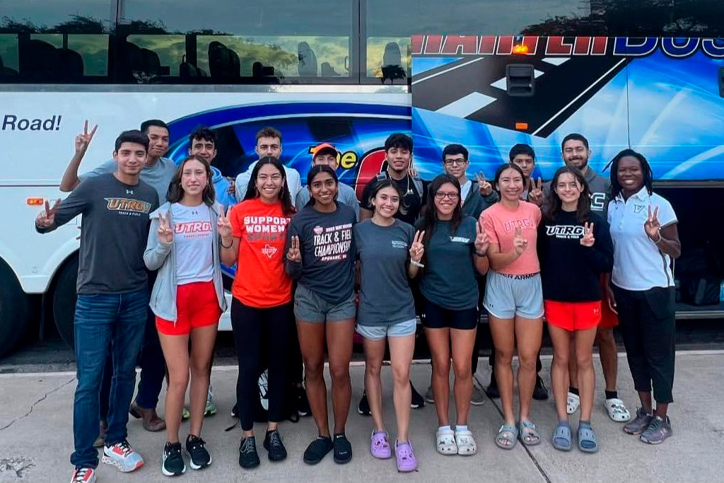Several individuals gather in front of a bus, contemplating the advantages and disadvantages of renting a bus for group travel.